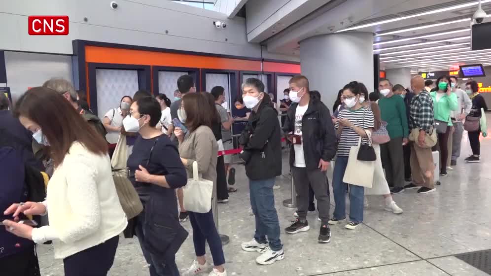 Hong Kong passengers wait in long lines to buy tickets of cross-provincial trains
