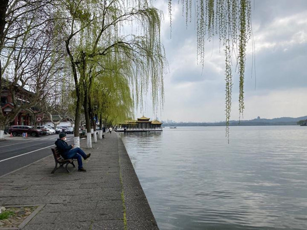 visitor sit along west lake.jpg