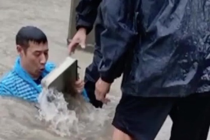 Chinese community officer dives underwater to clear blocked drain